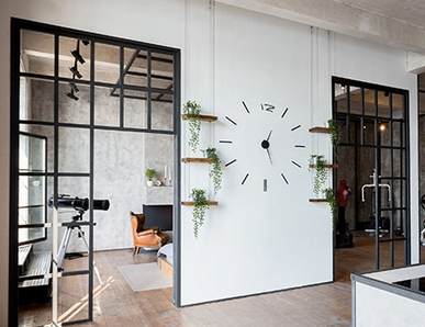 Türen im Loft-Stil mit schwarzen Metallrahmenelementen verbinden Küche und Wohnbereich.